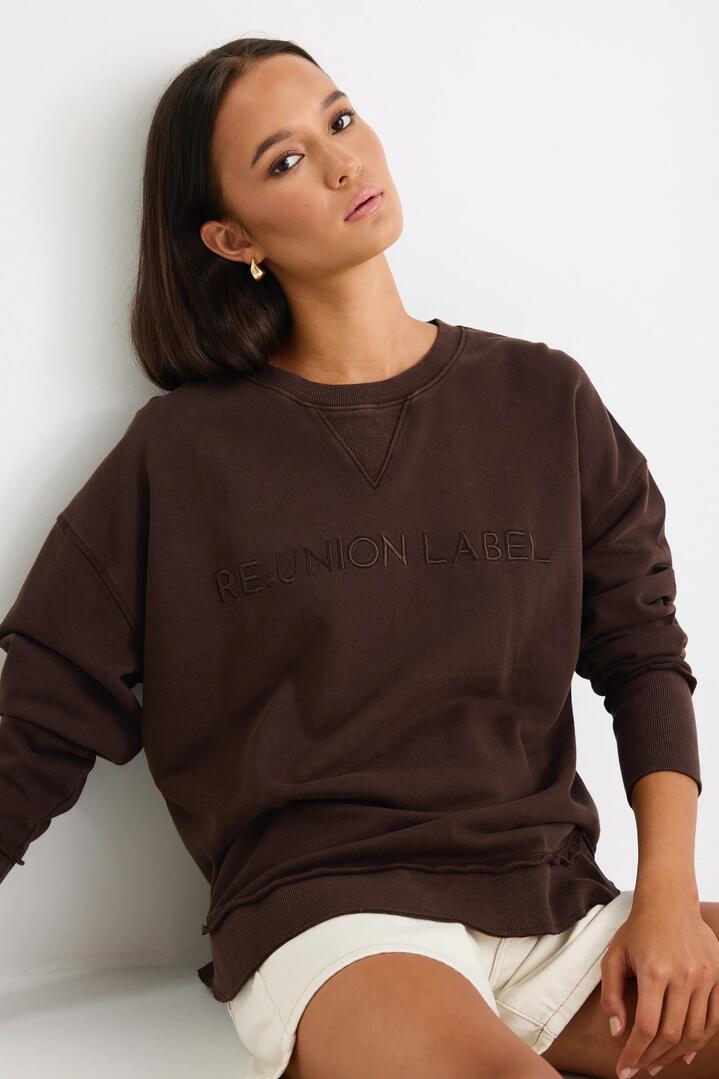 Image of a model wearing Outerwear. Product name - Scribe Chocolate Re:Union Sweatshirt in Chocolate colour by brand - RE:UNION Label