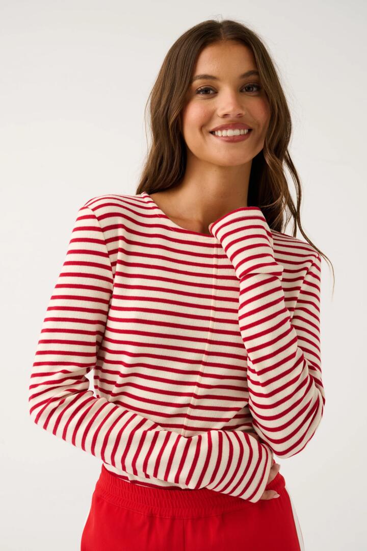 Image of a model wearing Tops. Product name - Aspyn Ruby Stripe Ivory LS Top in Red colour by brand - Cartel & Willow