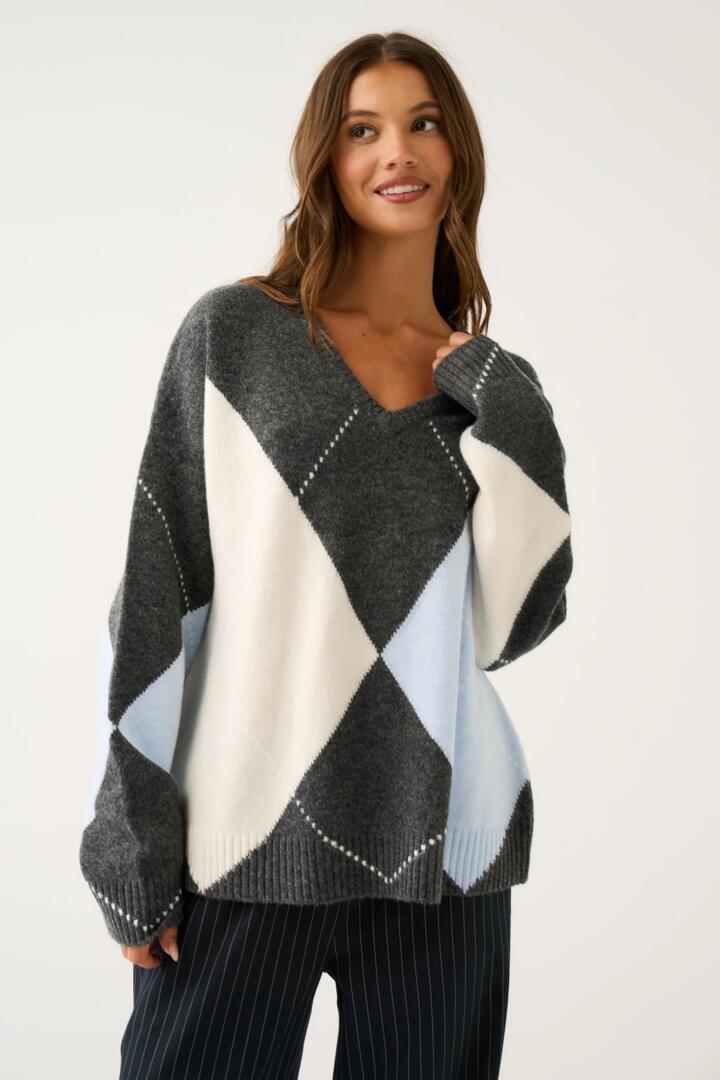Image of a model wearing Outerwear. Product name - Sophie Charcoal Argyle Knit in Grey colour by brand - Cartel & Willow