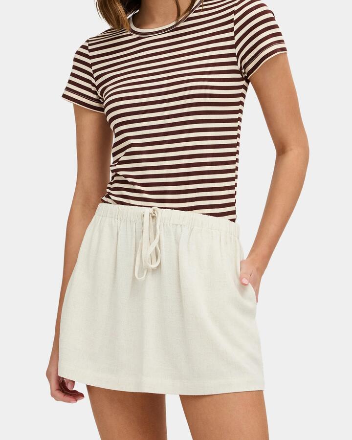 Image of a model wearing Skirts. Product name - Nunui Womens Anya Mini Skirt Natural Fleck in Natural Fleck colour by brand - Nunui