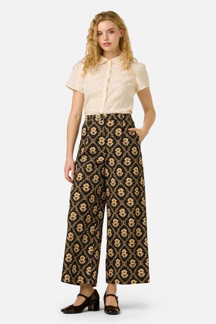 Image of a model wearing Pants. Product name - Luxe Fleur Geo Pant in Black/Cream colour by brand - Princess Highway