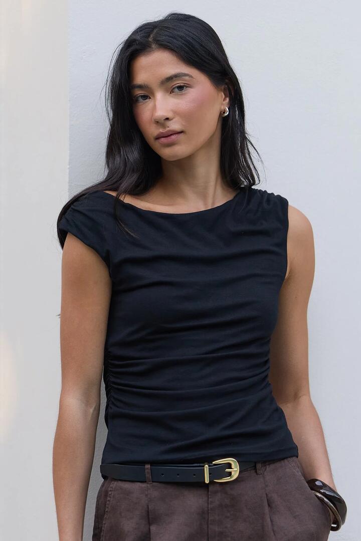 Image of a model wearing Tops. Product name - Backstreet Black Stretch Boat Neck Sleeveless Top in Black Stretch colour by brand - Stories be Told