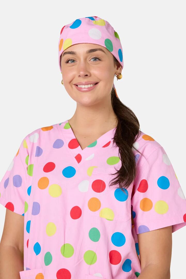 Image of a model wearing Uniforms & Workwear. Product name - Confetti Scrub Hat in Pink colour by brand - Scrubs With Love