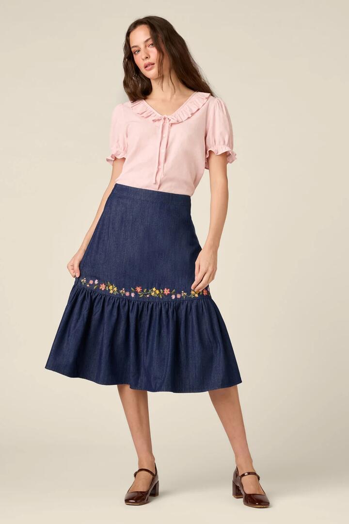 Image of a model wearing Skirts. Product name - Chloe Embroidered Denim Skirt in Blue Denim colour by brand - Princess Highway
