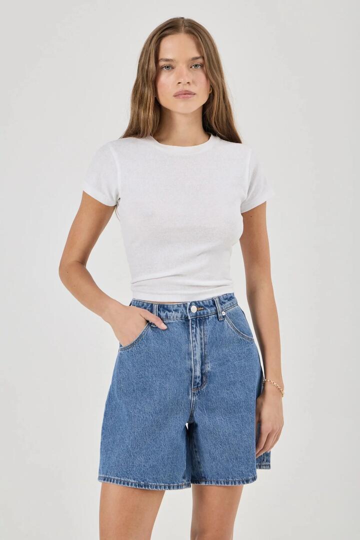 Image of a model wearing Shorts. Product name - Super Mirage Evie Mid Blue Denim Short in Blue colour by brand - Rollas