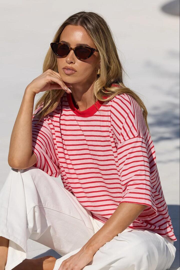 Image of a model wearing Tops. Product name - Cohesion Pink Red Stripe Oversized Contrast Binding Boxy SS Tee in Pink Red Stripe colour by brand - Stories be Told
