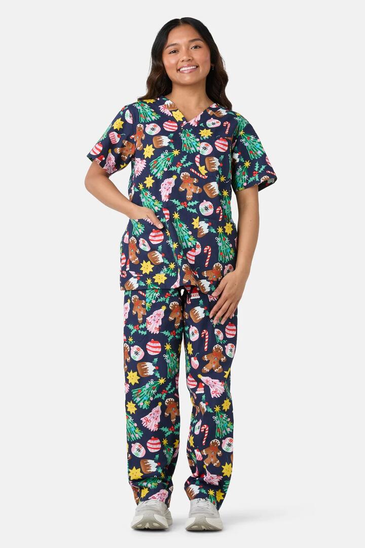 Image of a model wearing Uniforms & Workwear. Product name - Santa's Sweet Treats Scrub Set in Blue colour by brand - Scrubs With Love