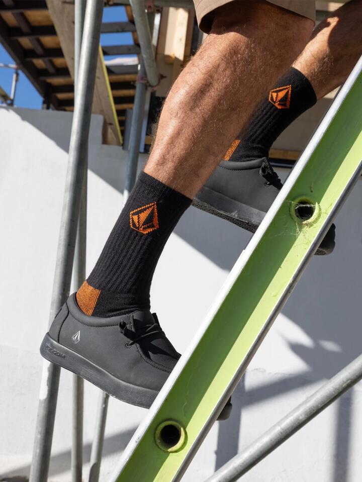 Image of a model wearing Uniforms & Workwear. Product name - Volcom Mens 3 Pack Volcom Workwear Socks Black in Black colour by brand - Volcom