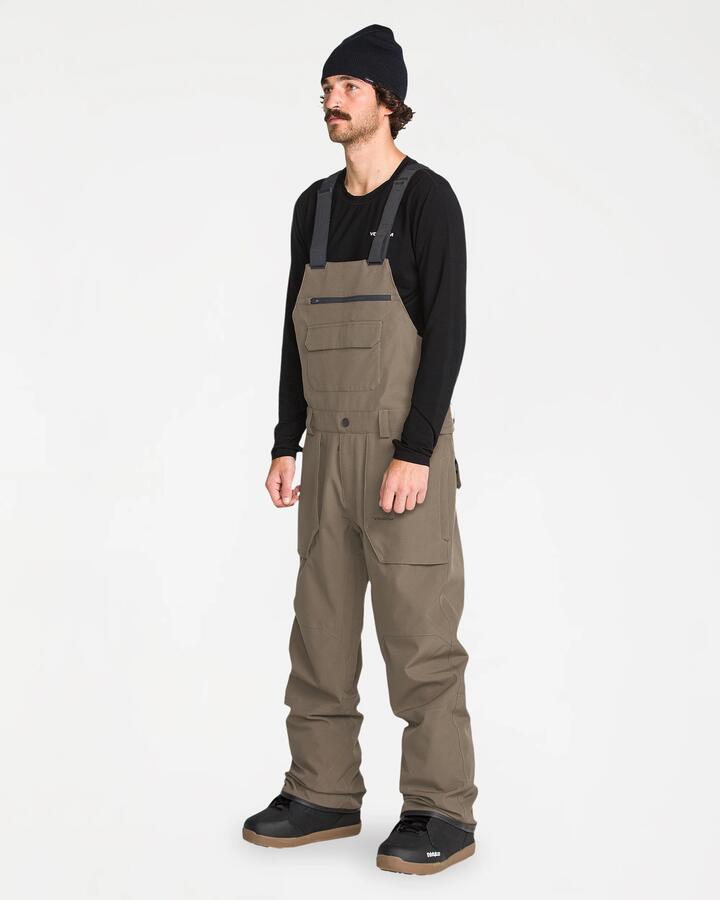 Image of a model wearing Pants. Product name - Volcom Mens Roan Bib Overall Pants Teak in Teak colour by brand - Volcom