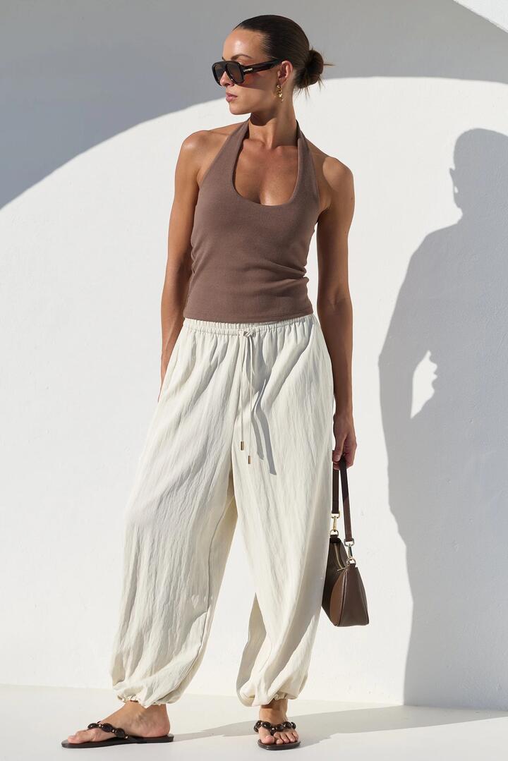 Image of a model wearing Pants. Product name - Offduty Off White Elastic Waist Balloon Pants in Off White colour by brand - Stories be Told