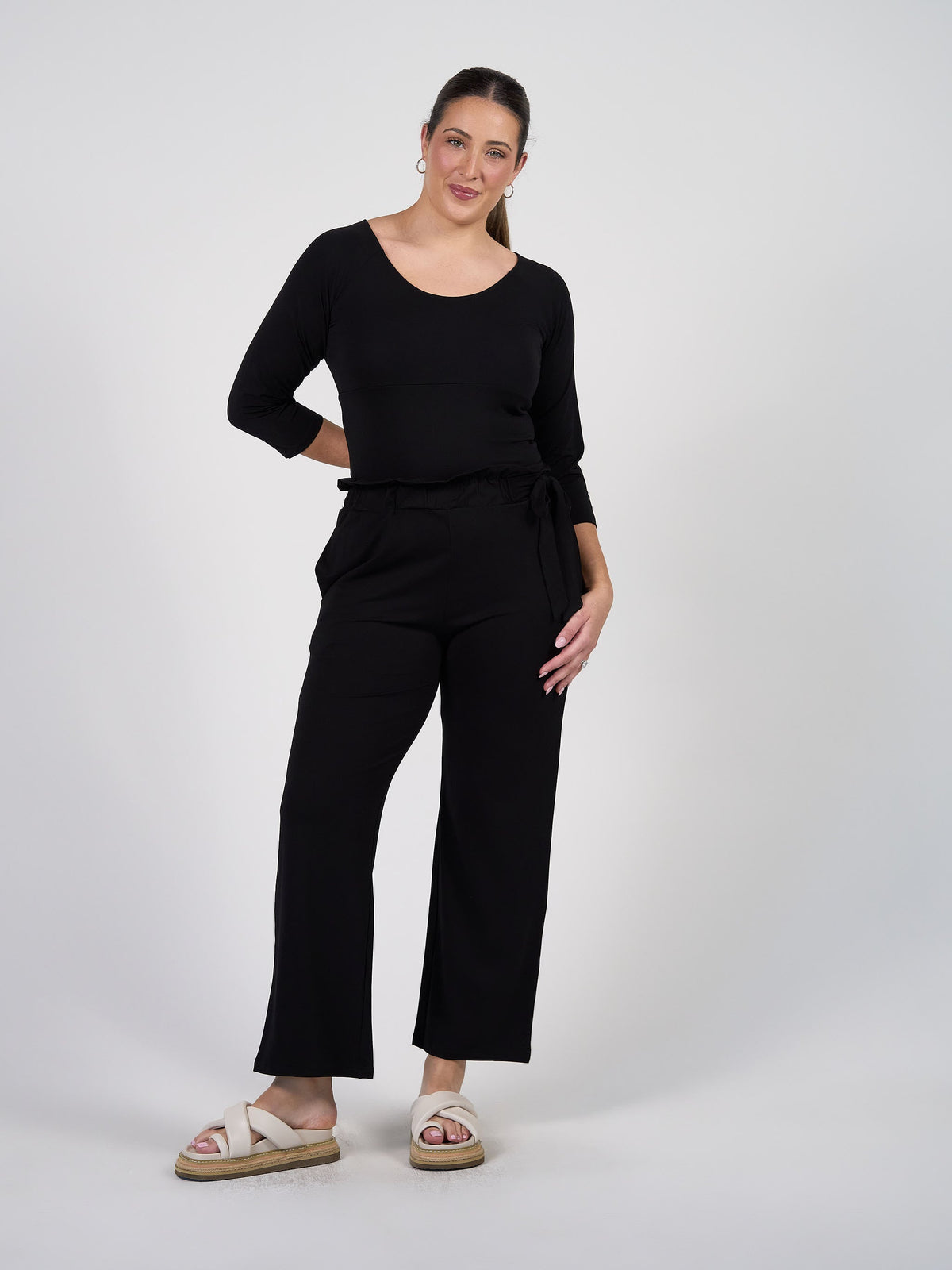 Image of a model wearing Tops. Product name - Ava 3/4 Sleeve Cropped Bamboo Top Black in Black colour by brand - Lou Lou
