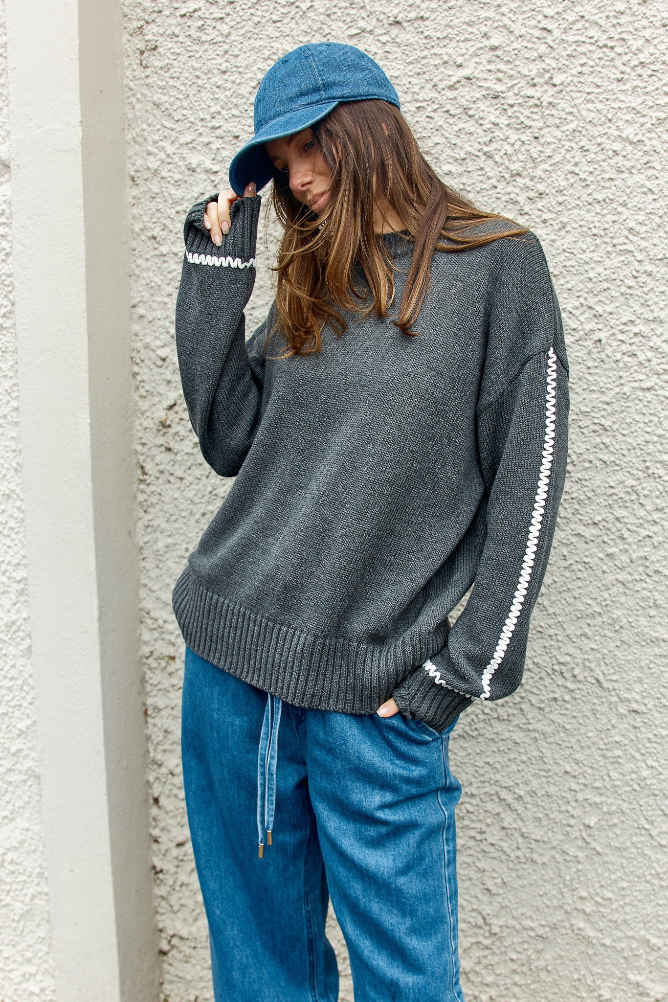Image of a model wearing Outerwear. Product name - Contrast Stitch Sweater Charcoal in Charcoal colour by brand - Betty Basics