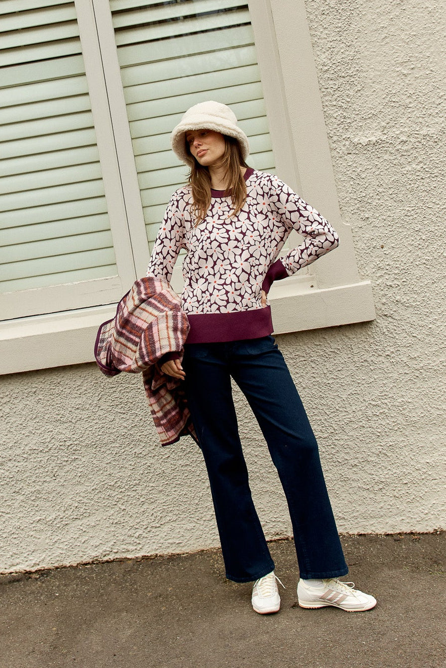 Image of a model wearing Outerwear. Product name - Maisie Sweater Wine Petal Jacquard in Wine Petal Jacquard colour by brand - Betty Basics