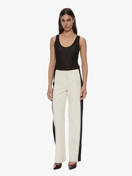 Image of a model wearing Pants. Product name - Tuxedo Contrast Silk Trouser in Black colour by brand - Christopher Esber