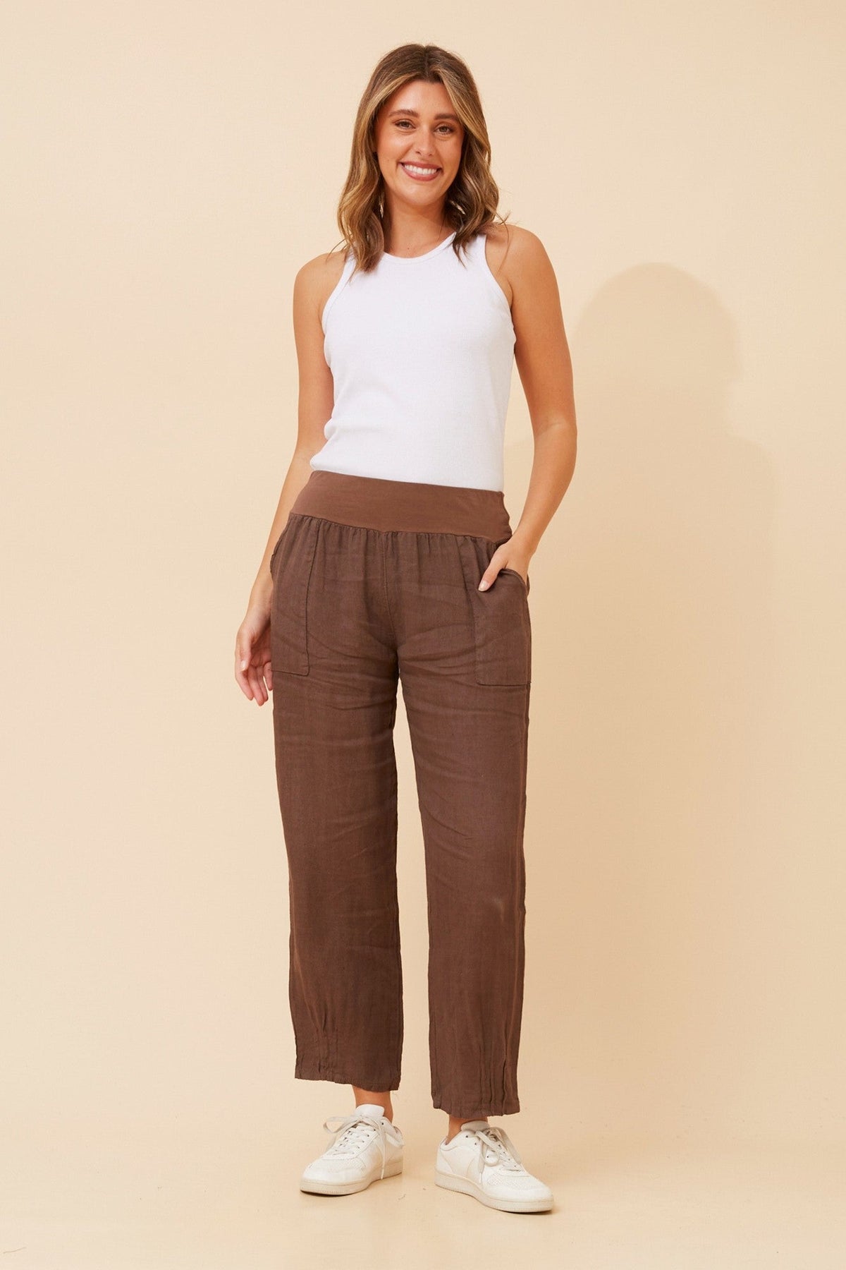 Image of a model wearing Pants. Product name - FINN SOLID LINEN PANTS in Bitter Chocolate colour by brand - BOTTEGA MODA