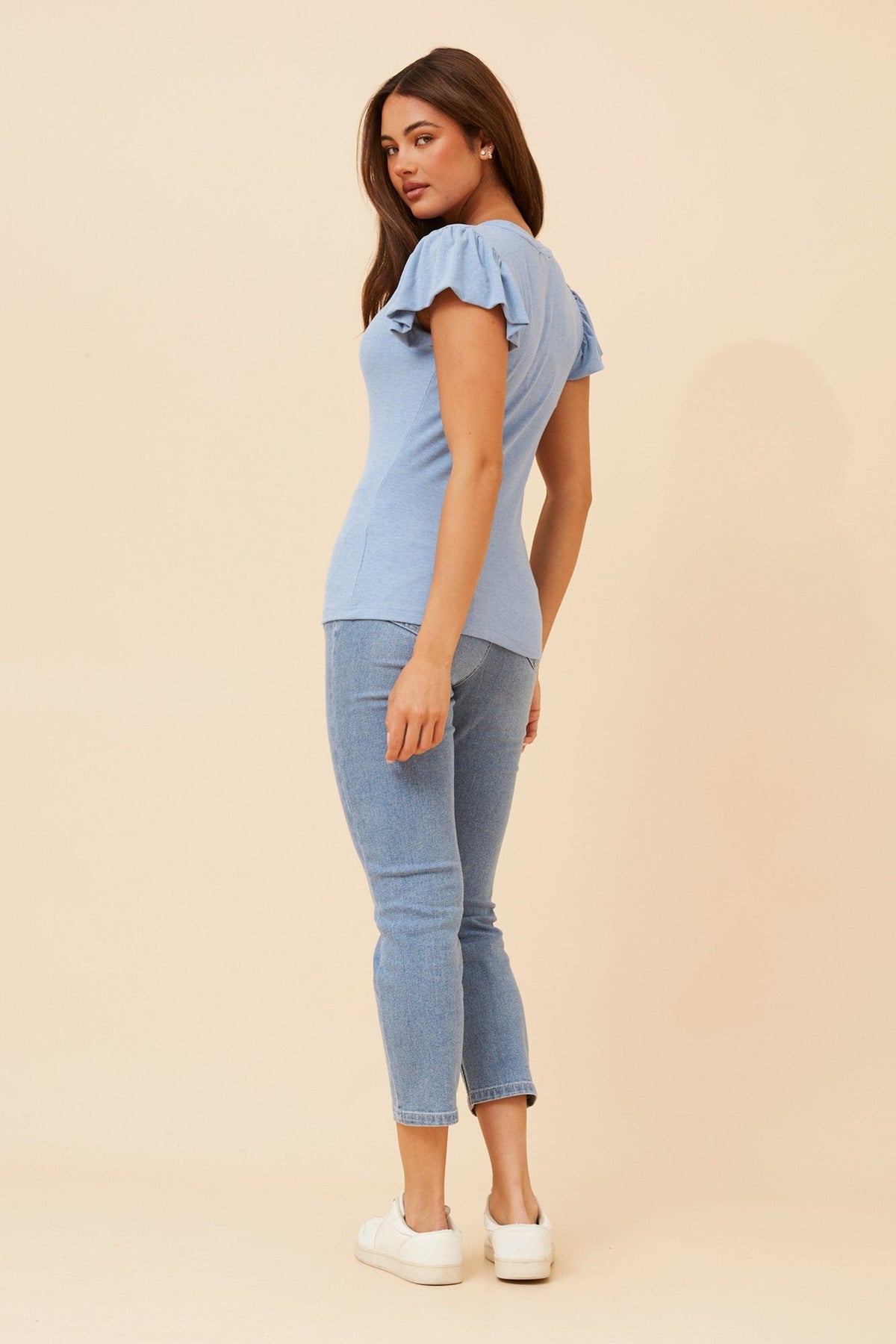 Image of a model wearing Tops. Product name - BRISA FRILL TOP in Blue Jean colour by brand - Caroline Morgan Australia