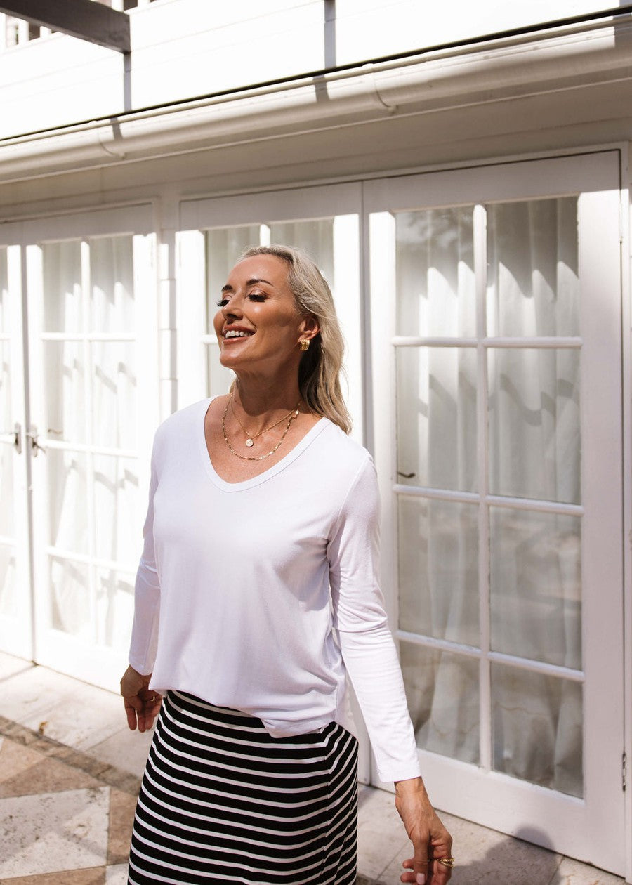 Image of a model wearing Tops. Product name - Sia V Neck Bamboo Longsleeve Top White in White colour by brand - Lou Lou