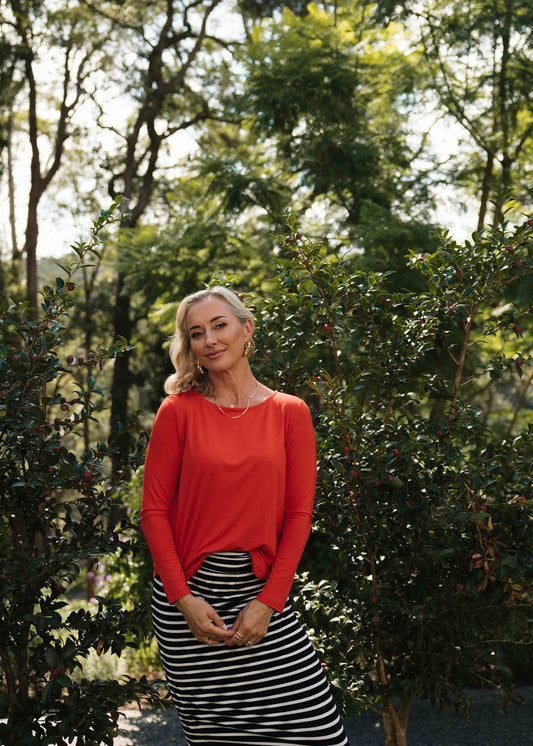 Image of a model wearing Tops. Product name - Adele Long Sleeve Bamboo Top Fiery Red in Fiery Red colour by brand - Lou Lou
