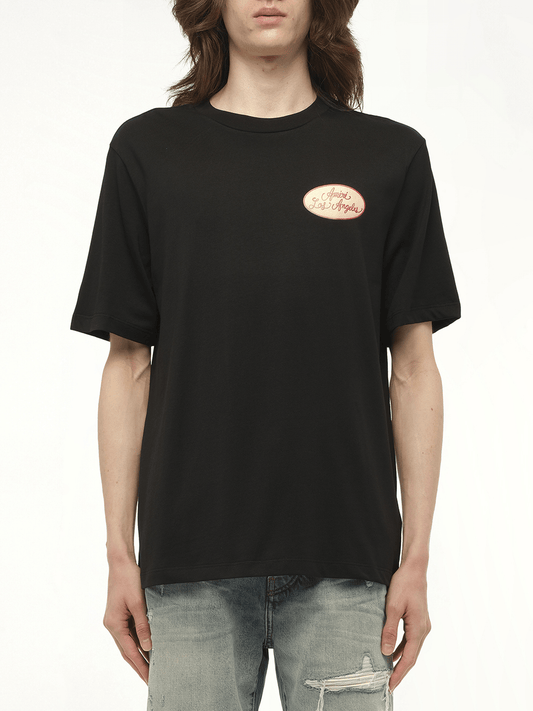 Image of a model wearing Tops. Productname: AMIRI Station Patch T-Shirt in BLACK colour by brand - AMIRI