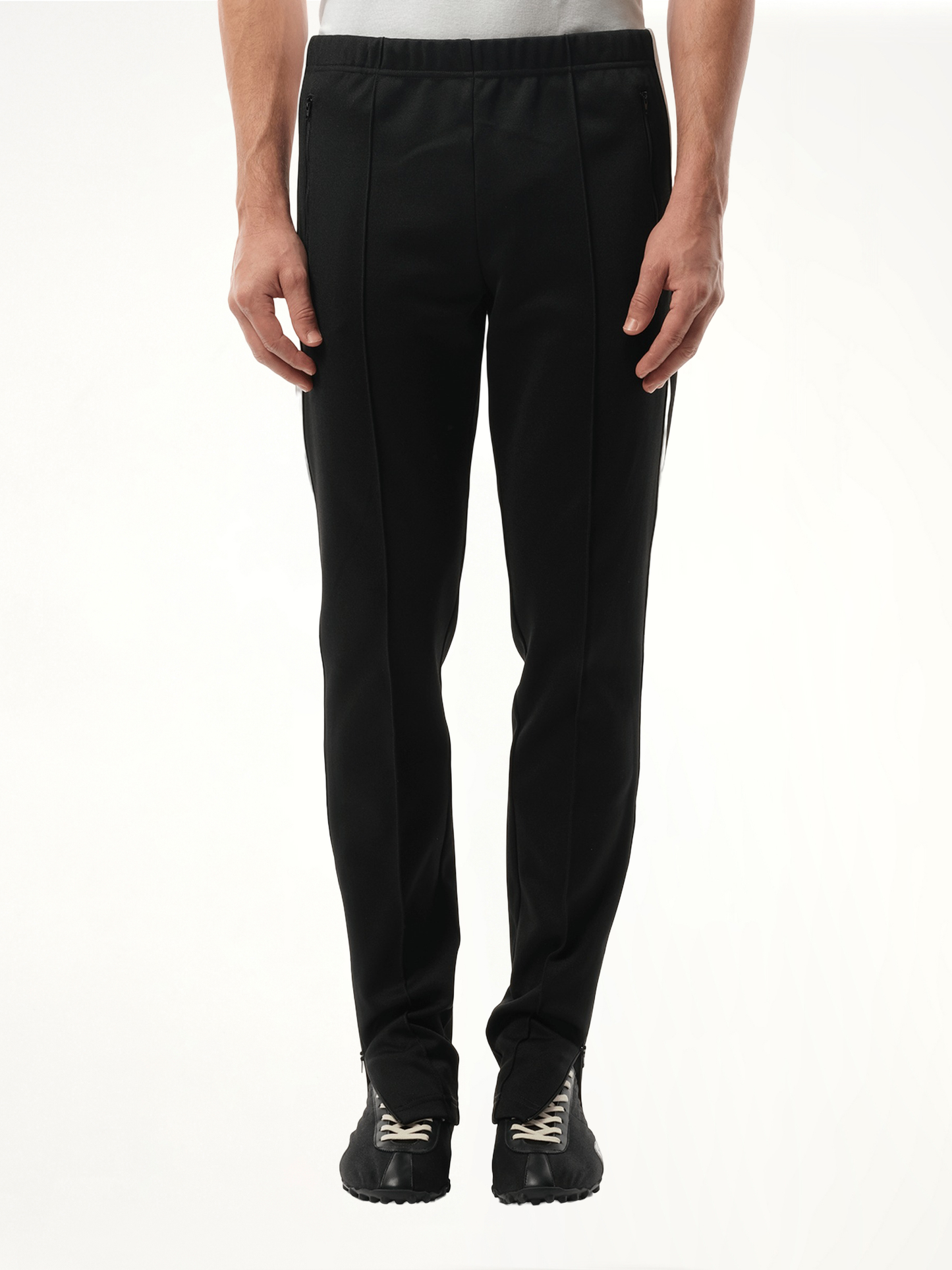 Image of a model wearing Pants. Productname: MAISON MARGIELA Track Pants in BLACK colour by brand - MAISON MARGIELA