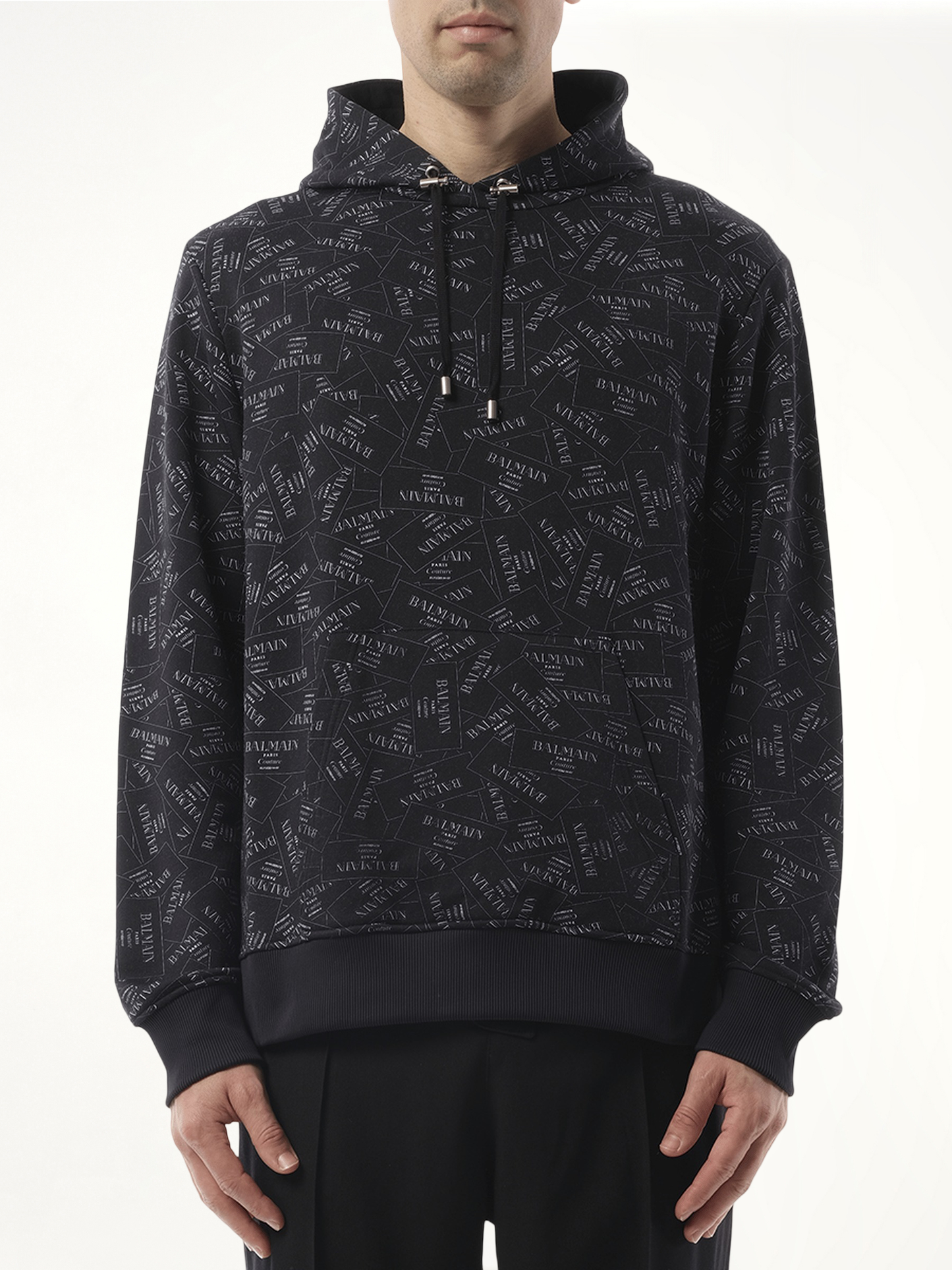 Image of a model wearing Outerwear. Productname: BALMAIN Allover Couture Label Hoodie in BLACK colour by brand - BALMAIN