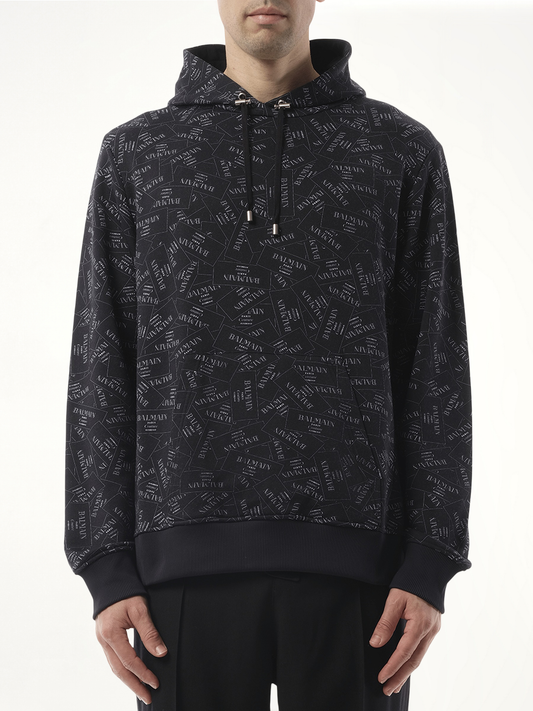 Image of a model wearing Outerwear. Productname: BALMAIN Allover Couture Label Hoodie in BLACK colour by brand - BALMAIN