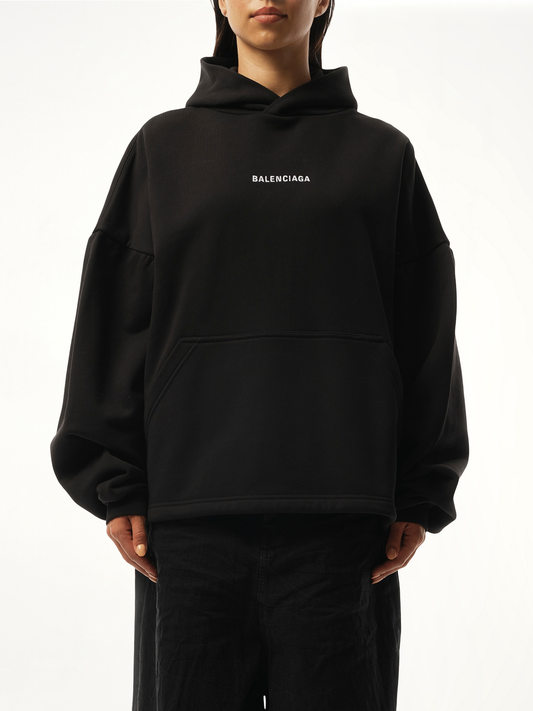 Image of a model wearing Outerwear. Productname: BALENCIAGA Logo Embroidered Hoodie in Black colour by brand - BALENCIAGA