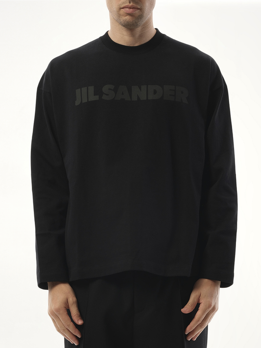 Image of a model wearing Tops. Product name - Tonal Jil Sander Logo Long Sleeve T-Shirt in Black colour by brand - JIL SANDER