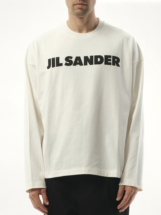 Image of a model wearing Tops. Product name - Jil Sander Logo Long Sleeve T-Shirt in Porcelain colour by brand - JIL SANDER