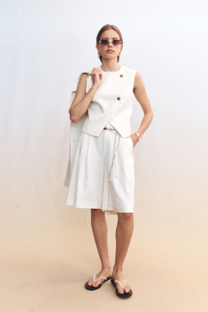 Image of a model wearing Tops. Product name - Junia Vest Ivory in Ivory colour by brand - Blanca Studio