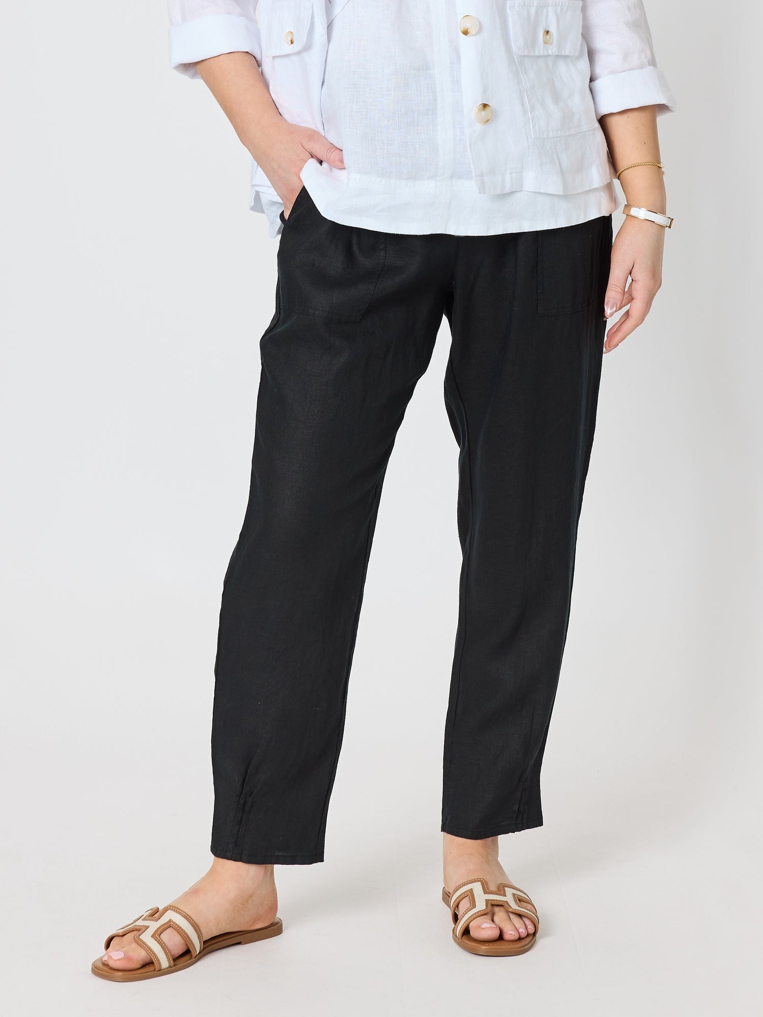 Image of a model wearing Pants. Product name - Sarah Linen Pleat Hem Pant Black in Black colour by brand - Gordon Smith