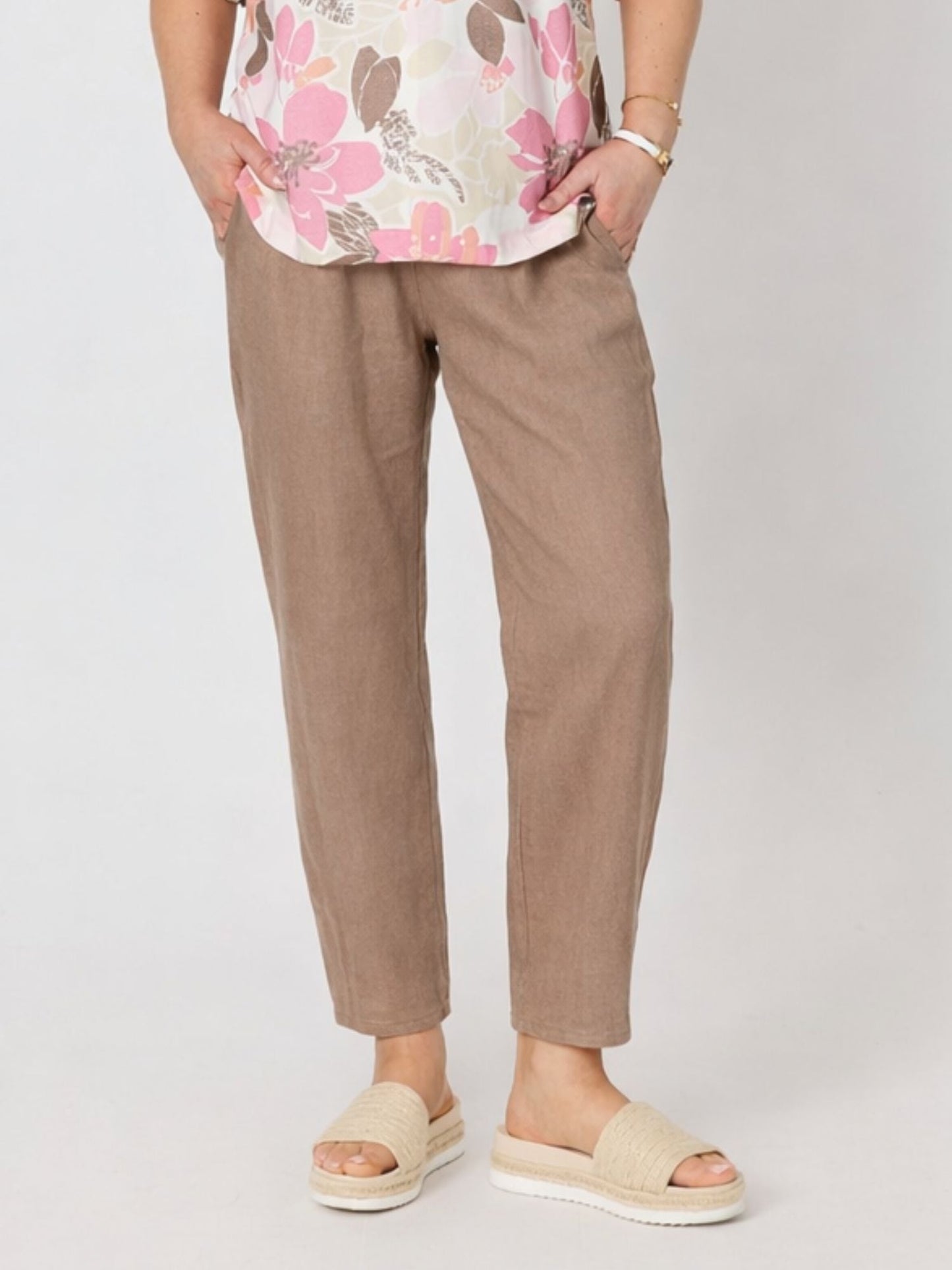 Image of a model wearing Pants. Product name - Sarah Linen Pleat Hem Pant Mocha in Mocha colour by brand - Gordon Smith