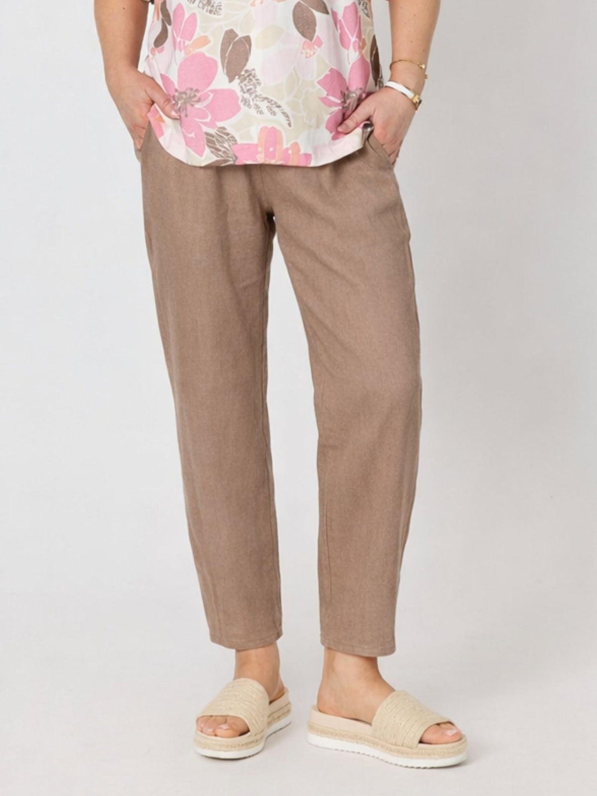 Image of a model wearing Pants. Product name - Sarah Linen Pleat Hem Pant Mocha in Mocha colour by brand - Gordon Smith
