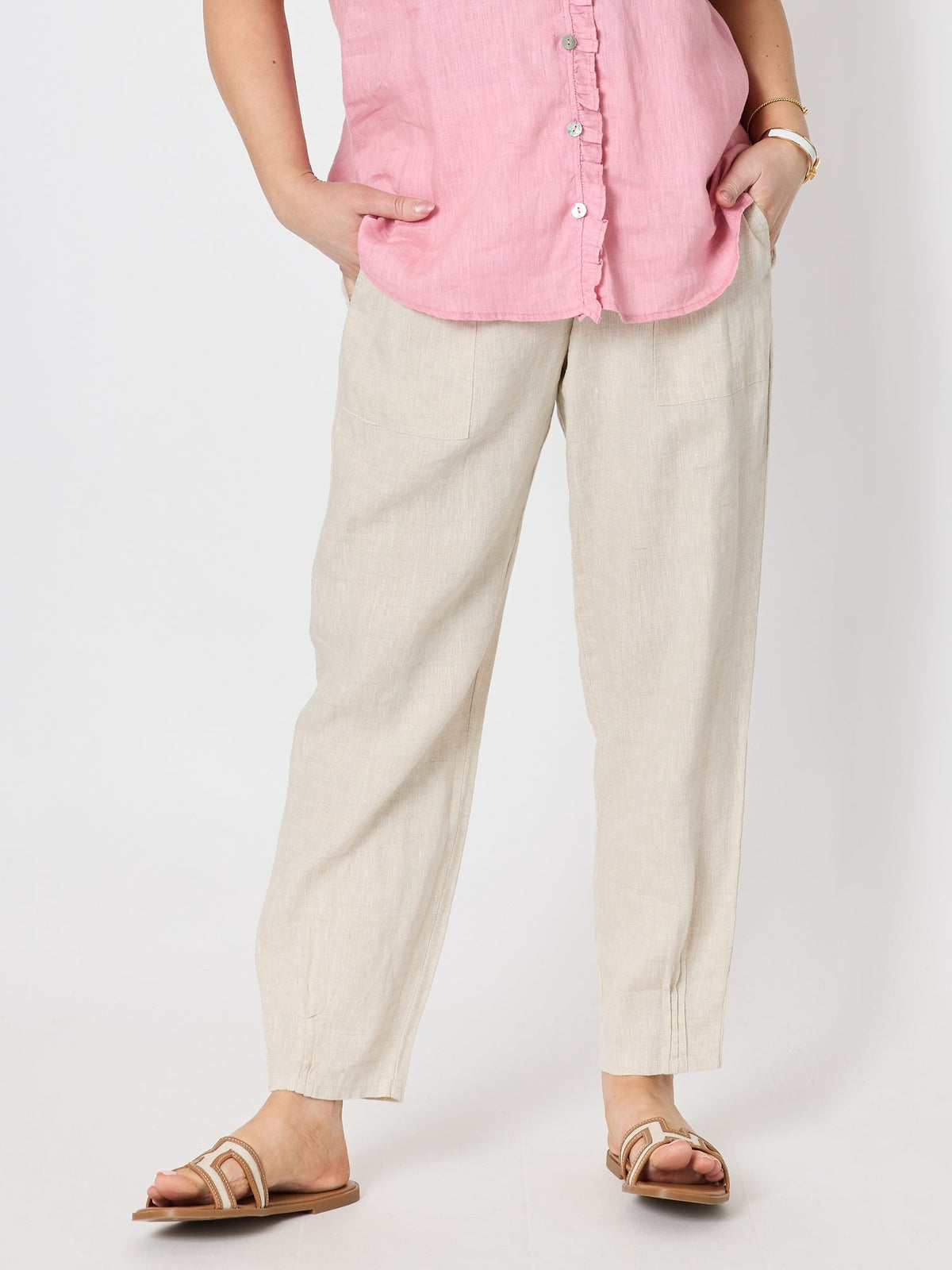 Image of a model wearing Pants. Product name - Sarah Linen Pleat Hem Pant Natural in Natural colour by brand - Gordon Smith