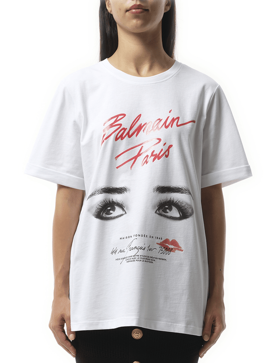 Image of a model wearing Tops. Productname: BALMAIN Balmain Paris Eyes Print T-Shirt in White colour by brand - BALMAIN