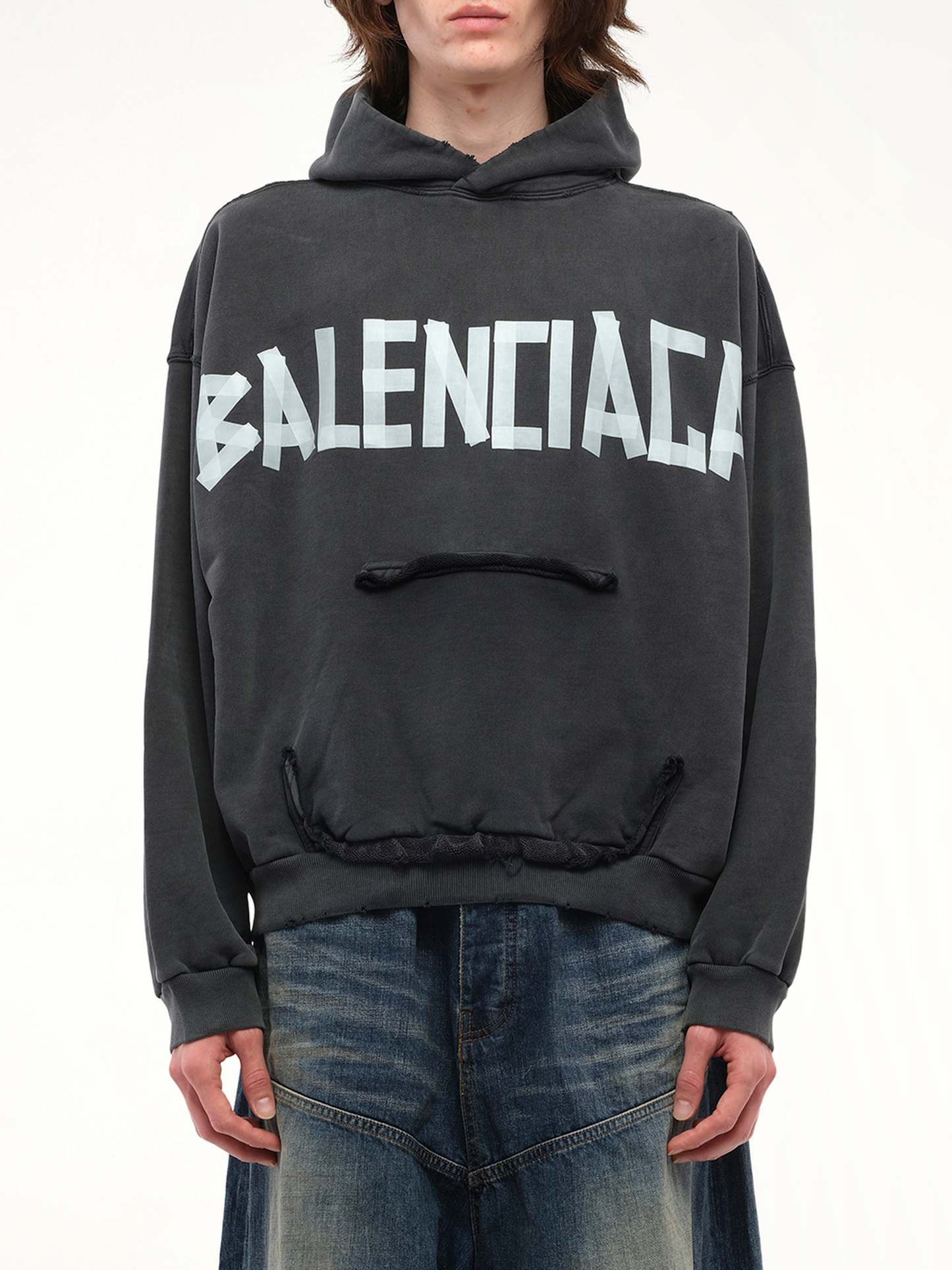 Image of a model wearing Outerwear. Productname: BALENCIAGA Tape Type Ripped Pocket Hoodie in Black colour by brand - BALENCIAGA