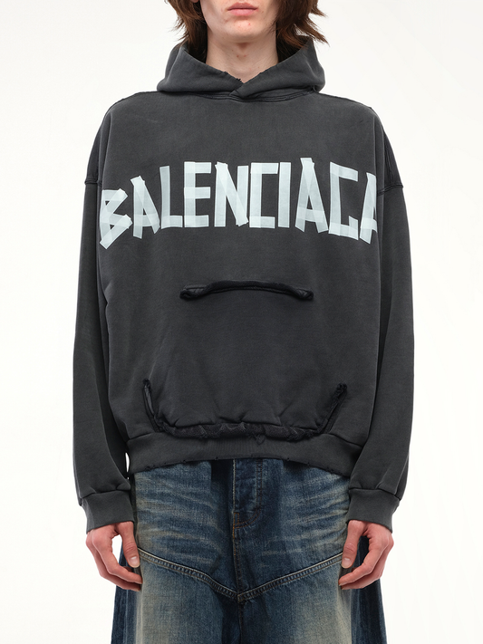 Image of a model wearing Outerwear. Productname: BALENCIAGA Tape Type Ripped Pocket Hoodie in Black colour by brand - BALENCIAGA