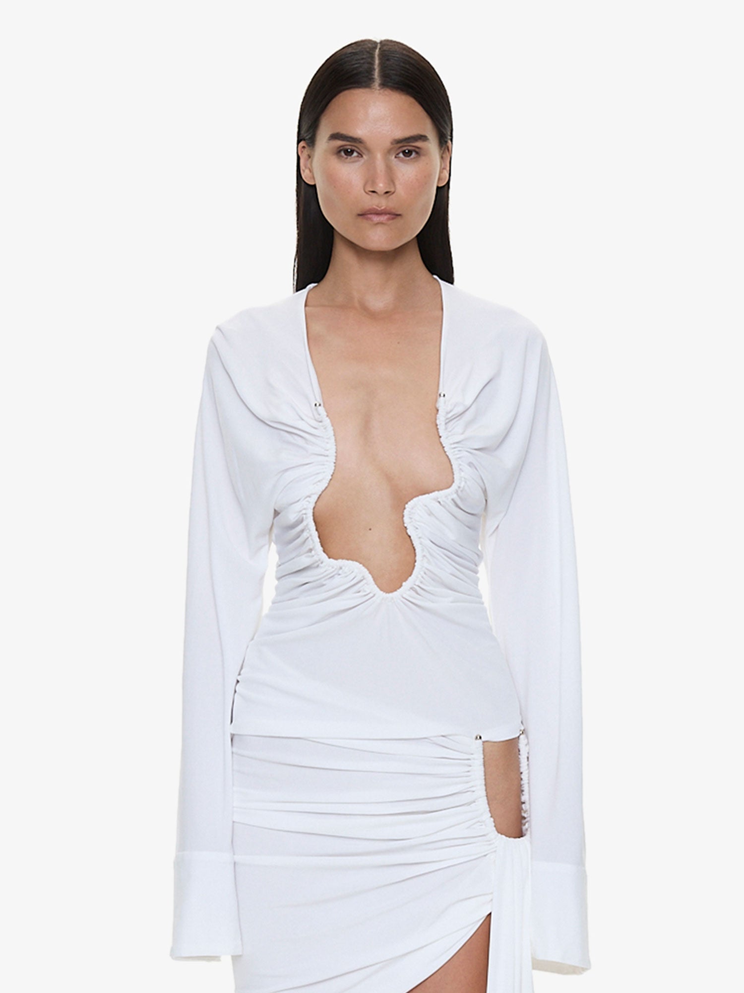 Image of a model wearing Tops. Product name - Salacia Ruched Long Sleeve Top in White colour by brand - CHRISTOPHER ESBER