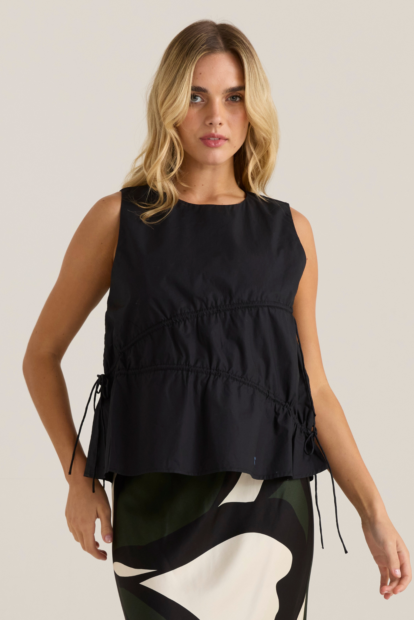 Image of a model wearing Tops. Product name - Elin Gathered Tie Top Black in Black colour by brand - Sass Clothing