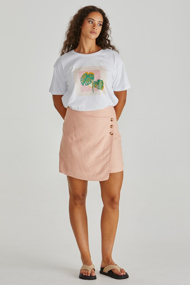 Image of a model wearing Skirts. Product name - Coast Mini Wrap Skirt Peach in Peach colour by brand - Sass Clothing