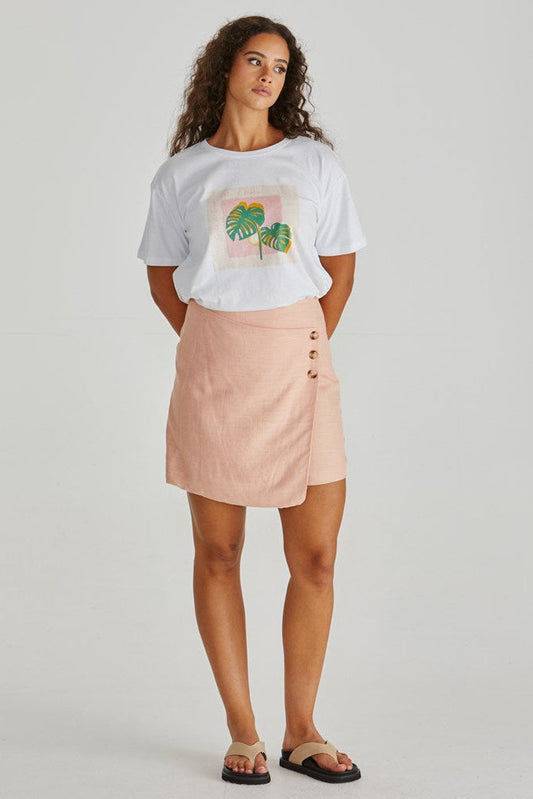 Image of a model wearing Skirts. Product name - Coast Mini Wrap Skirt Peach in Peach colour by brand - Sass Clothing