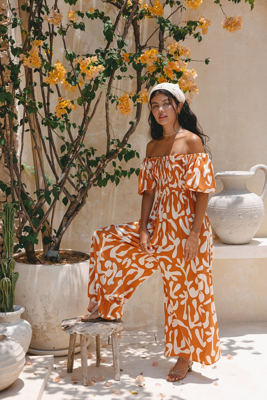 Image of Bodysuits. Product name - Solange Rust Orange Abstract Puff Sleeve Jumpsuit in Orange colour by brand - Heychic