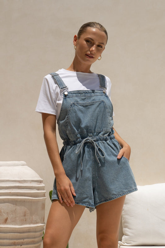Image of a model wearing Outerwear. Productname: HEYCHIC Wren Blue Denim Short Overalls in Blue colour by brand - HEYCHIC