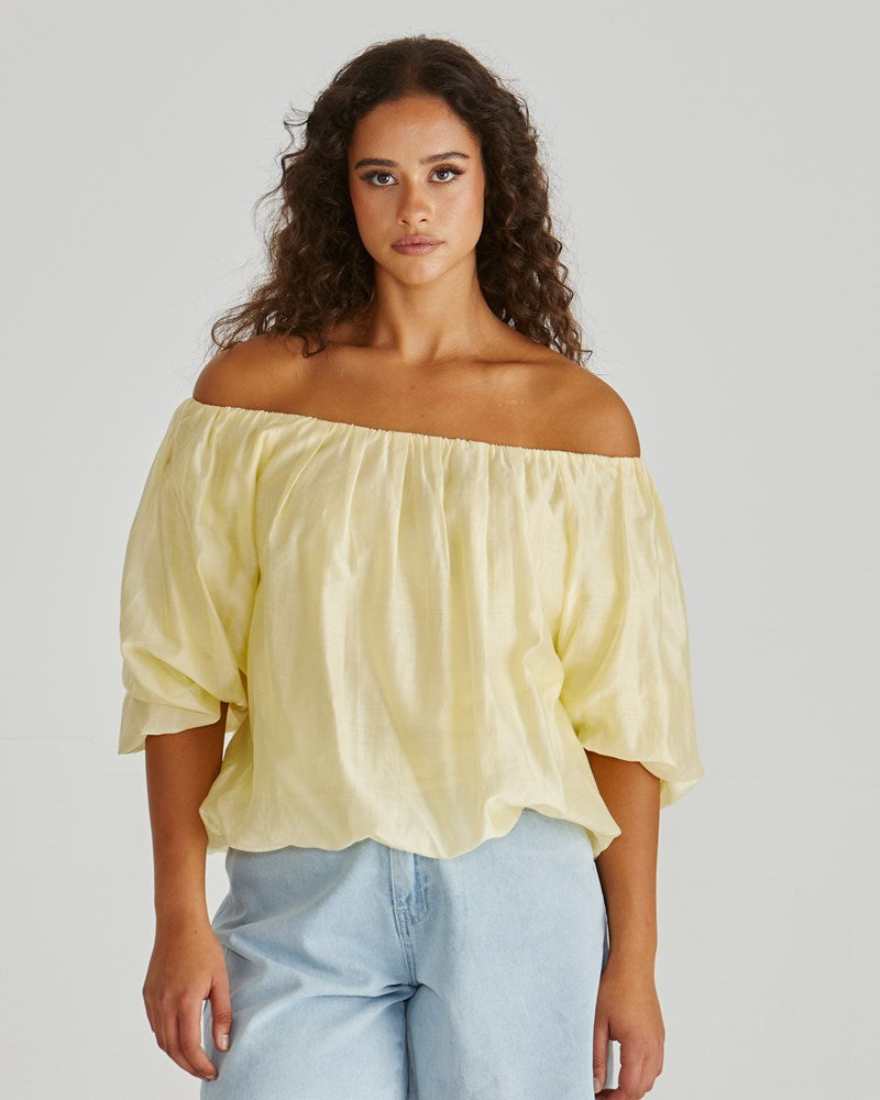 Image of a model wearing Tops. Product name - Sofie Off Shoulder Top Yellow in Yellow colour by brand - Sass Clothing