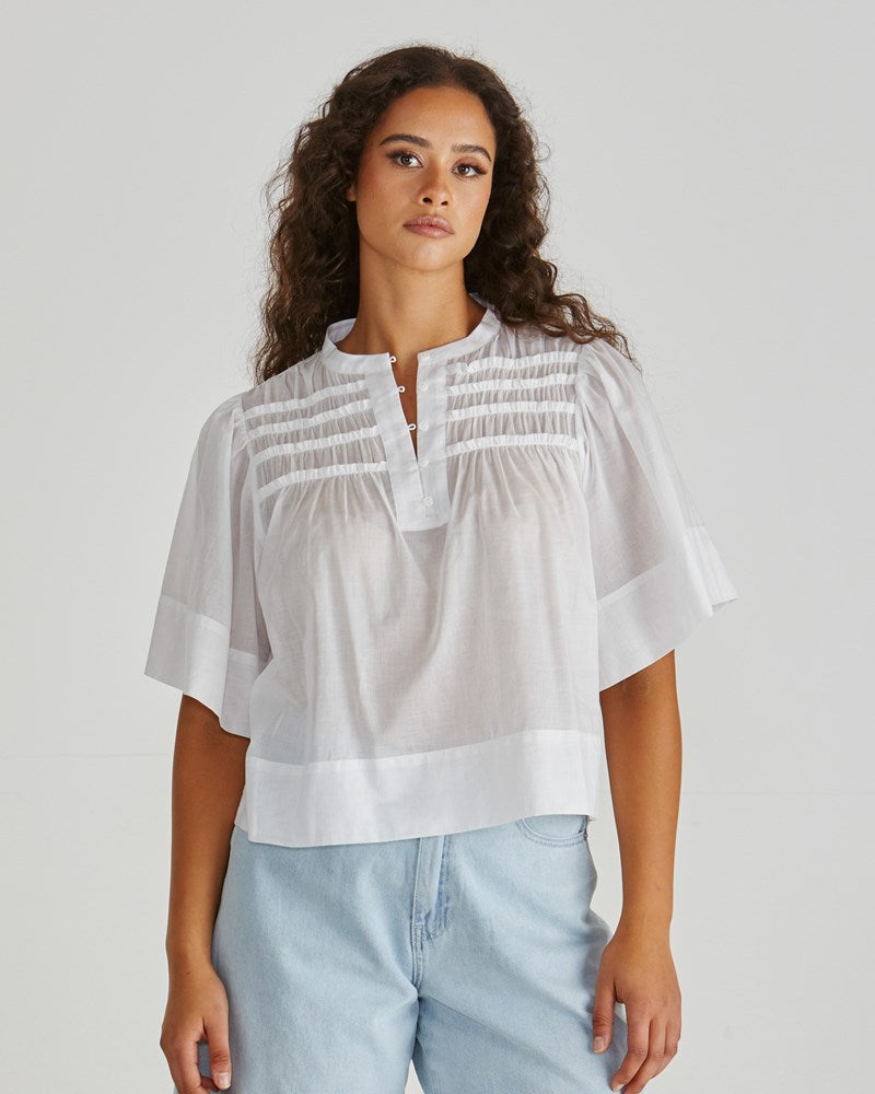 Image of a model wearing Tops. Product name - Pammi Ruffle Yoke Blouse White in White colour by brand - Sass Clothing