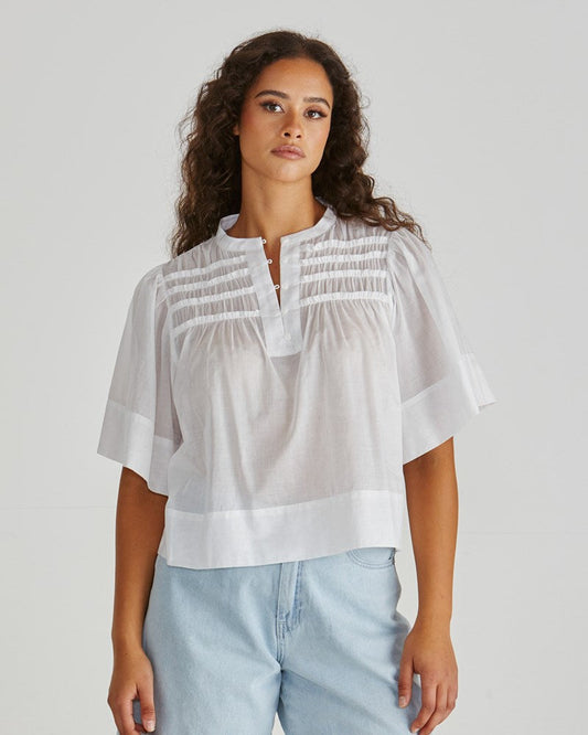 Image of a model wearing Tops. Product name - Pammi Ruffle Yoke Blouse White in White colour by brand - Sass Clothing