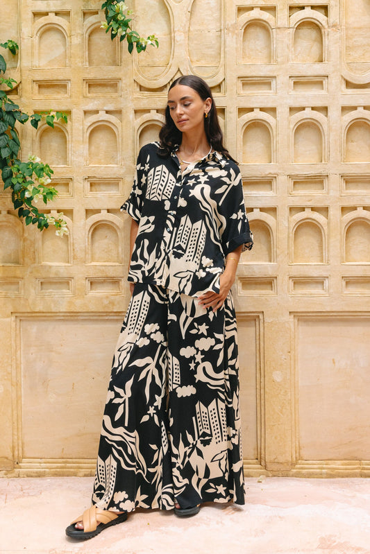 Image of a model wearing Pants. Productname: Heychic Cali Abstract Wide Leg Pants in Black colour by brand - Heychic