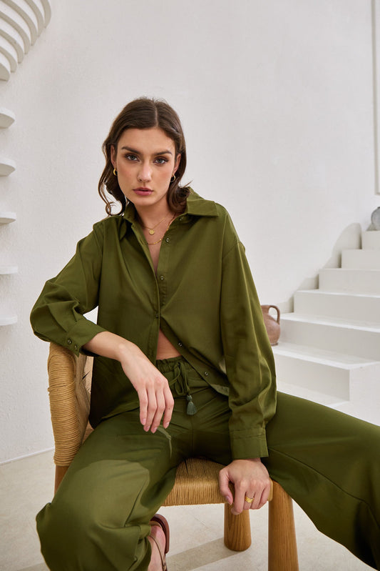 Image of a model wearing Tops. Product name - Page Khaki Green Cupro Shirt in Green colour by brand - Heychic