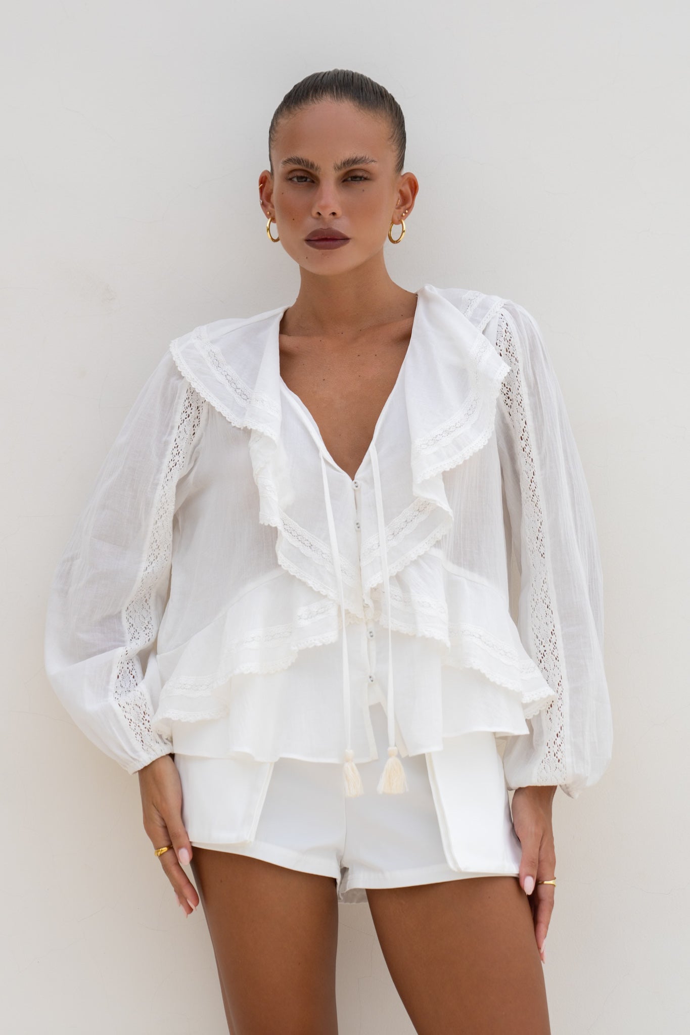 Image of a model wearing Tops. Productname: Heychic Valentina Off-White Ruffle Blouse in White colour by brand - Heychic