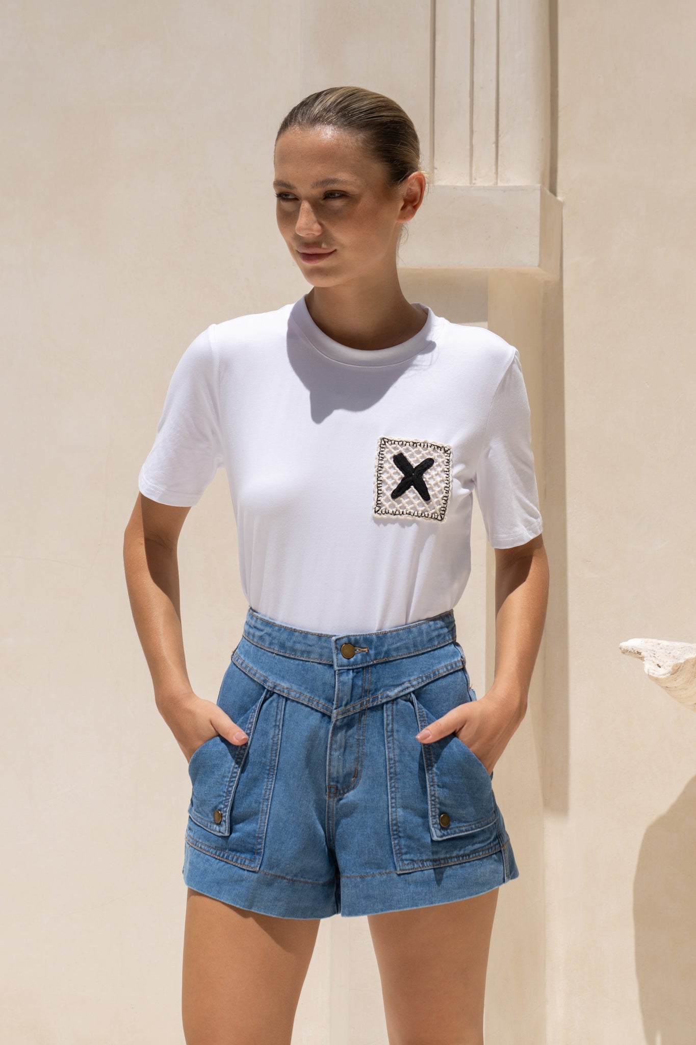 Image of a model wearing Tops. Productname: HEYCHIC Xio X Knit Patch White T-Shirt in White colour by brand - HEYCHIC